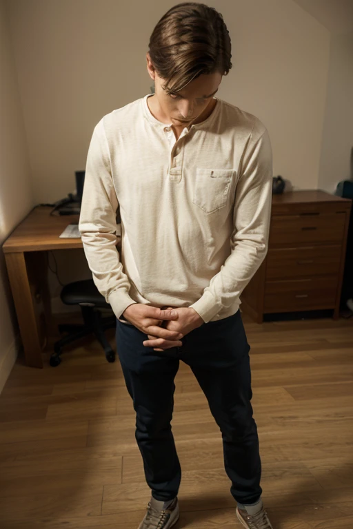 A man is standing up and looking down while folding his hands