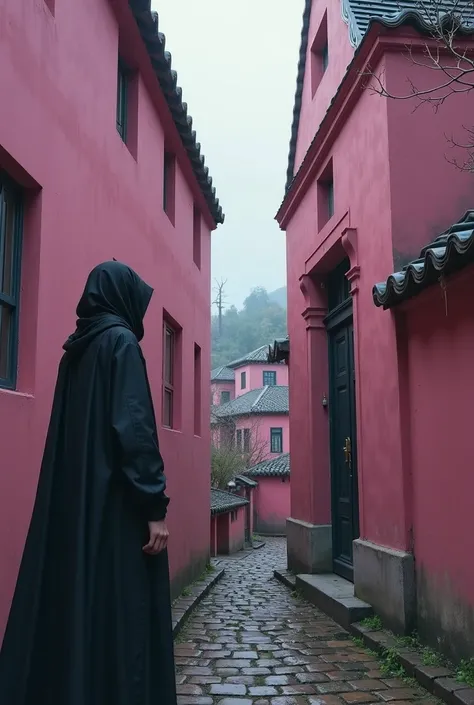 Two pink buildings with a narrow corridor leading to an Arab area with old houses ,Next to the two buildings is a woman wearing a black Arab cloak that covers her all from her foot to her face 