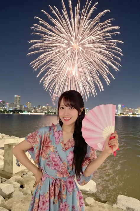 "Japanese woman wearing a colorful yukata, standing on a riverbank, with fireworks exploding in the sky behind her. She is smiling while holding a folding fan in one hand, and the soft glow of the fireworks illuminates her face. The setting is peaceful, wi...