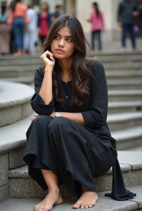 A young woman, likely in her late s or early twenties, of South Asian ethnicity, is seated on a set of stone steps. She is wearing a black, loose-fitting, traditional dress, a kurta, with wide-legged pants. Her bare feet rest on the steps.  She appears to ...