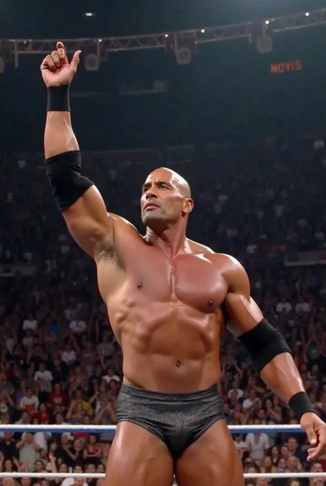 Dwayne Johnson sul ring, standing with his arm raised, the audience that screams in delirium around him. He wears wrestling shorts and classic black elbow pads. The arena lights illuminate him from above, highlighting his sculpted muscles. His face is prou...