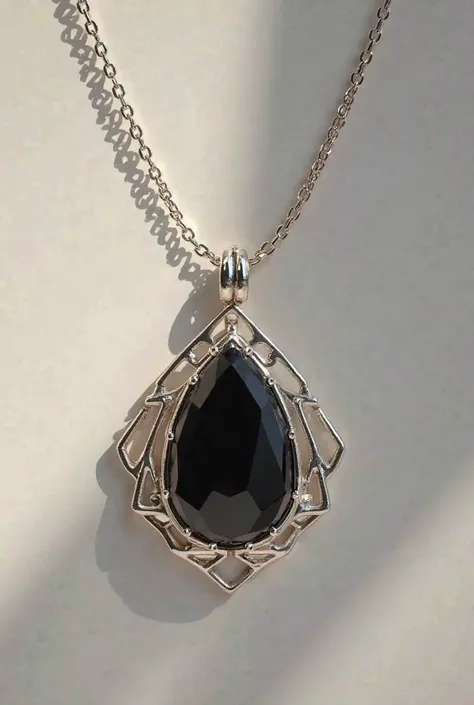 An incredibly sophisticated and elegant necklace, with a fine and delicate chain made of polished silver. The piece is adorned with a central onyx stone, deep black in color, that stands out with its subtle elegance. The stone is surrounded by a crafted si...