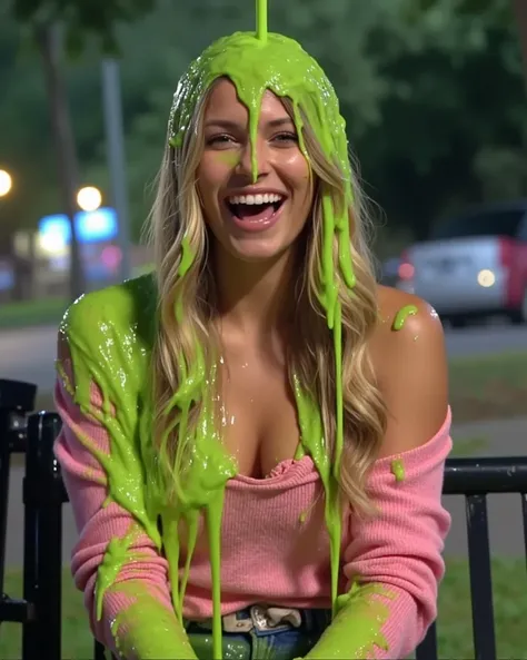 DSLR photograph of young woman with long wavy blonde hair sitting on a park bench at night, covered in thick, dripping green water. New York city skyline in the background. Bokeh. She wears an off-the-shoulder pink sweater with cleavage, which is partially...