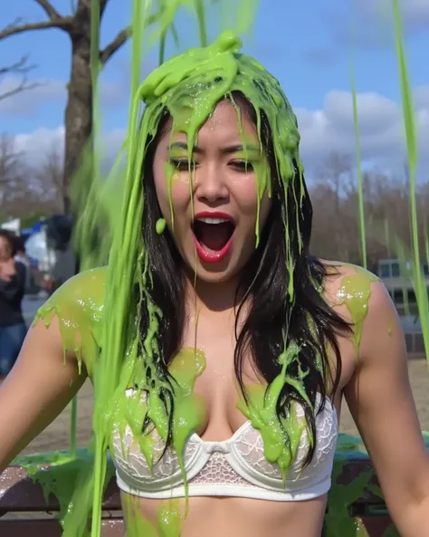 Film photograph of young Korean woman with long wavy black hair sitting on a park bench, covered in thick, dripping green water. She wears a white lace push-up bra, which is partially visible beneath the slime. White lace panties. She has long fake eyelash...