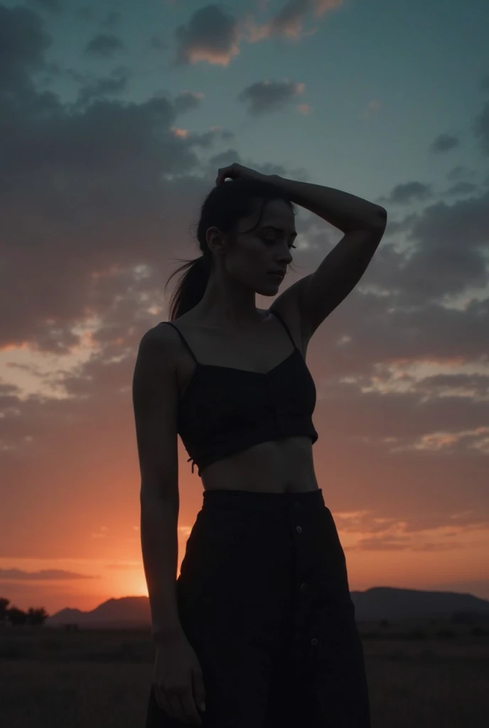 "A moody, cinematic silhouette of a young woman standing against a breathtaking sunset sky. The sky transitions from deep blue to warm orange and pink hues, with scattered clouds adding depth and texture. The woman, her long hair tied in a low ponytail, ge...