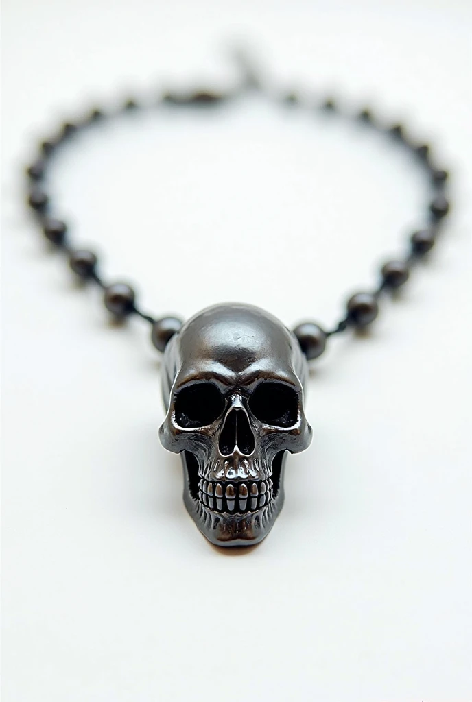 Necklace with a small skull made of black pearls without a lower jaw on a white background