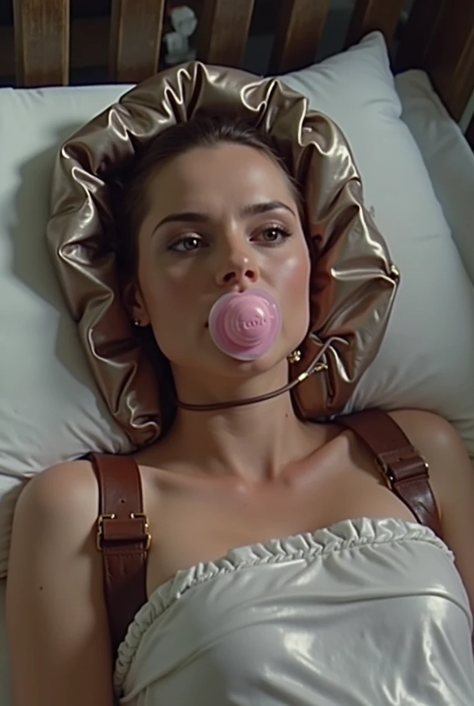 beautiful woman in a closed sleeping bag, Made of thin latex that is closed under the chin. She lies in a crib. The woman wears a pink pacifier for adults in her open mouth. On her head she wears a shiny latex hood with ruffles. She wears a climbing harnes...