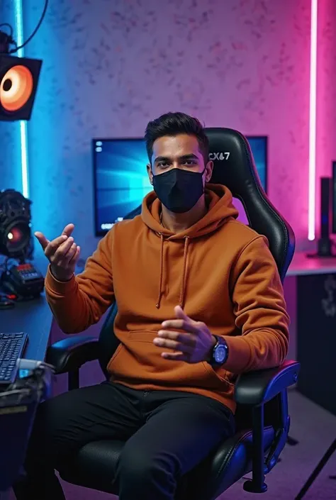 An Indian man is sitting confidently and upright, looking straight ahead, on a modern gaming chair in his YouTube studio. He is wearing a bright brown hoodie and a black face mask. His face is clearly visible and full of expression. He is gesturing with on...