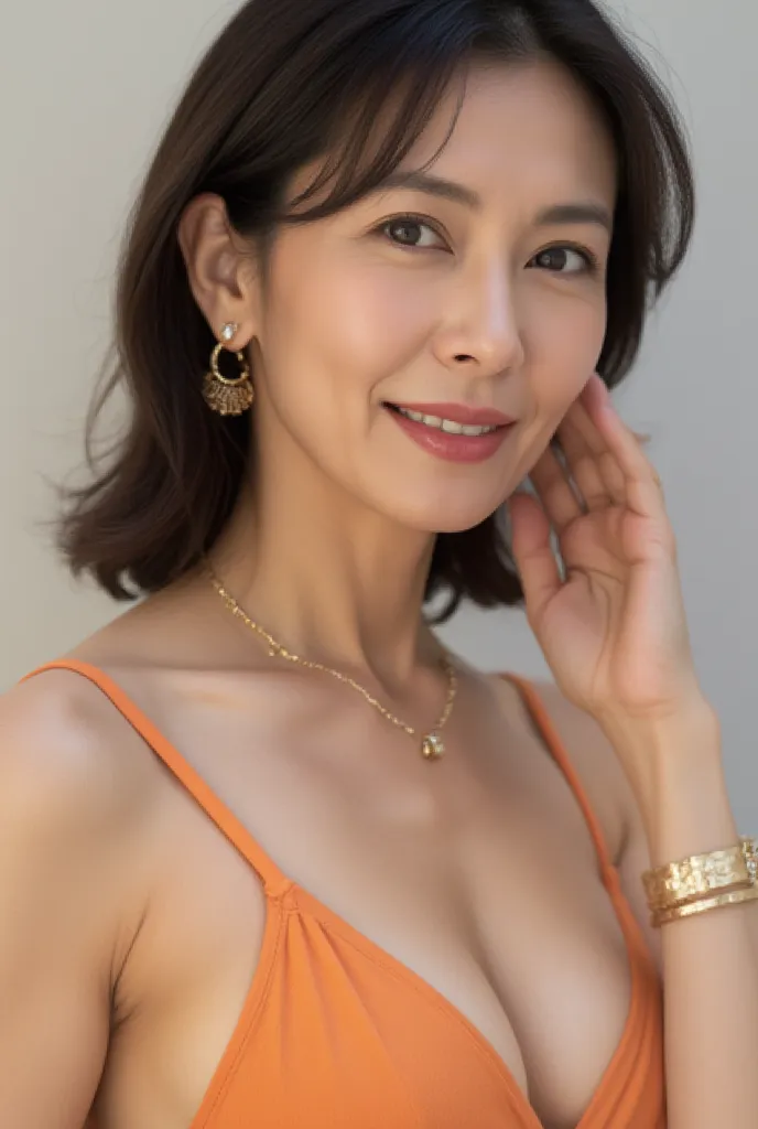 A close-up catalog image of a 46-year-old Japanese woman wearing an orange separate-type swimsuit with elegant jewelry. She has a natural hairstyle, minimal makeup, and fine laugh lines, giving her a graceful mature beauty. She wears a delicate gold chain ...