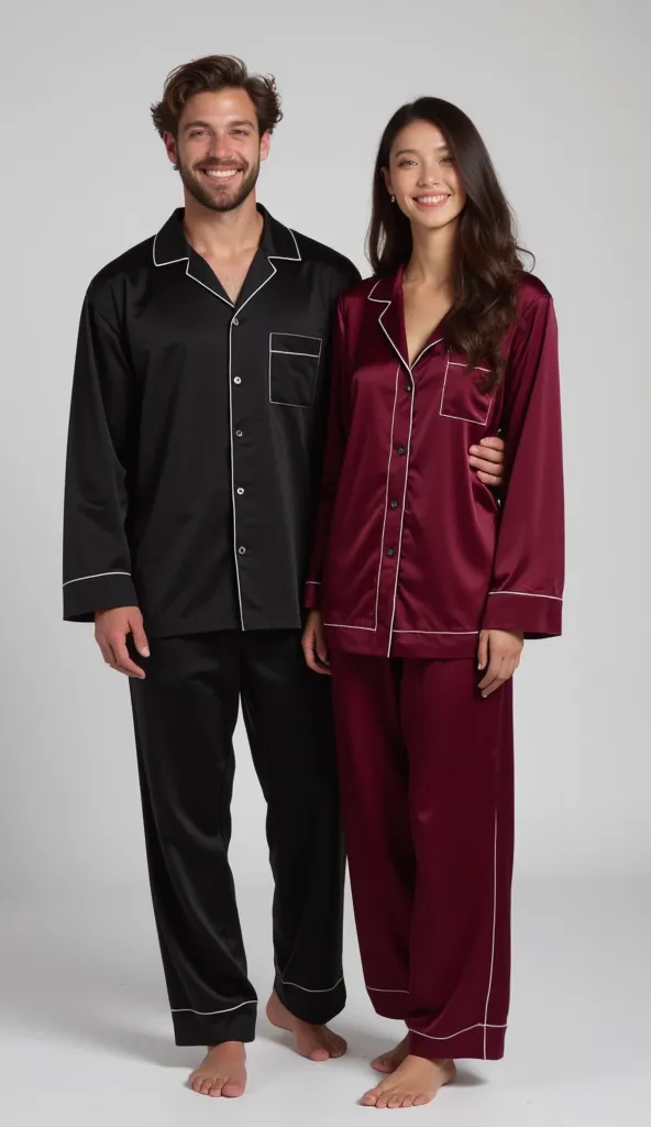 A man and a woman standing straight together, straight pose, looking straight, dressed in matching satin silk pajamas. The man wears black full-sleeved button-up top with a pocket and long pajama, with white piping, while the woman wears the same style in ...