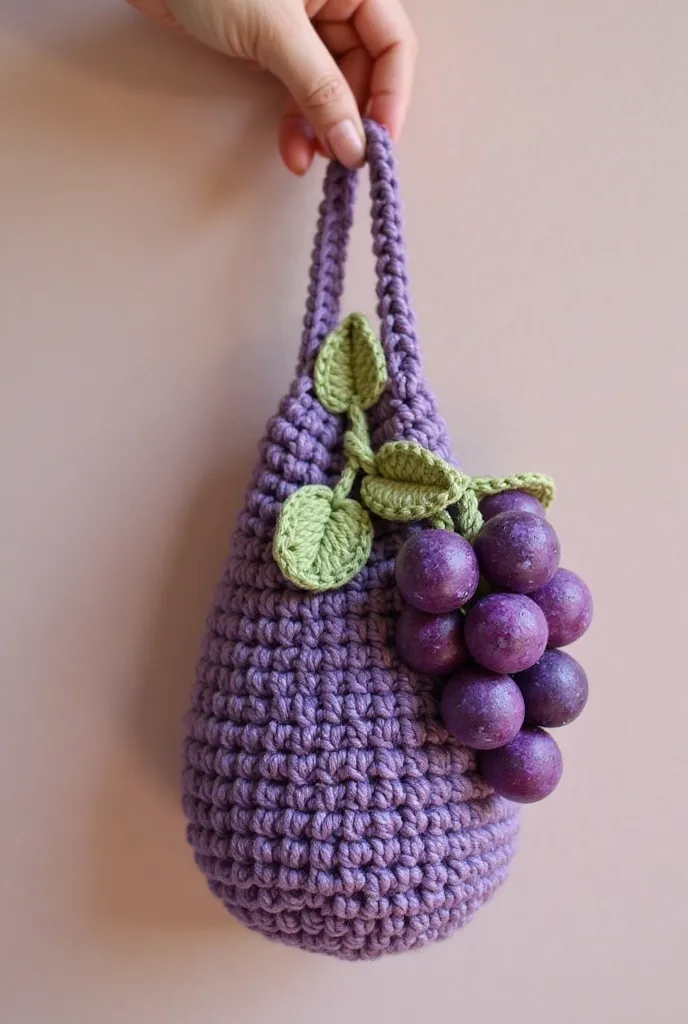 A crochet keychain bag , with grapes hanging