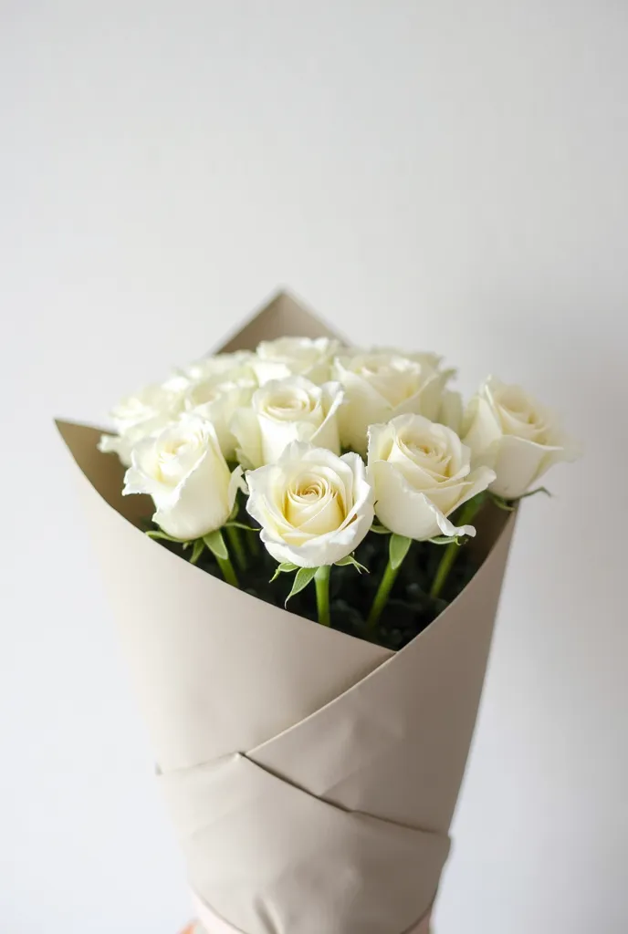 "A minimalist bouquet of white roses, carefully arranged in a round composition. The flowers are fresh, with smooth petals and thin green stems. The bouquet is packed in elegant floral packaging: matte beige or gray paper with soft folds, wrapped around th...