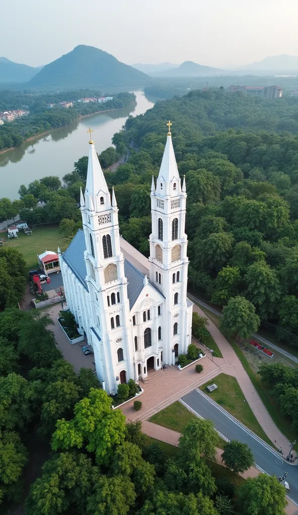 A majestic aerial view of Cái Bè Church, an elegant European-style Gothic church situated on the banks of the Tiền River. Its white facade and tall bell towers contrast beautifully against the lush green landscape