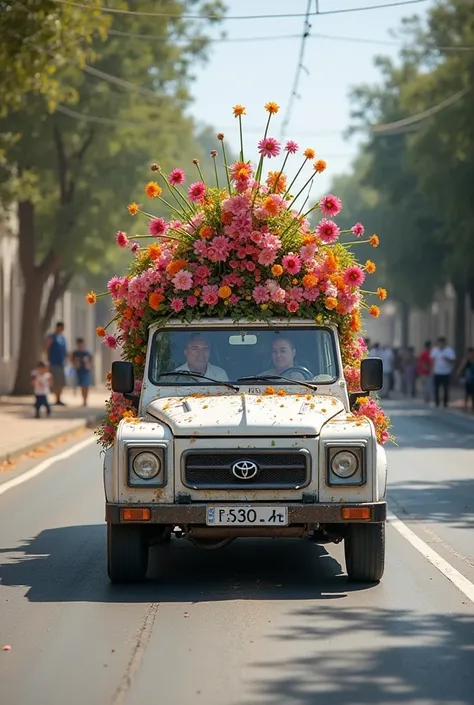 an image that is a photograph where there is a normal white vehicle that is Toyota and with a trailer that serves to pull an allegorical car decorated with flowers for Carnival and whatever they are driving along a sunny street I want the part of the trail...