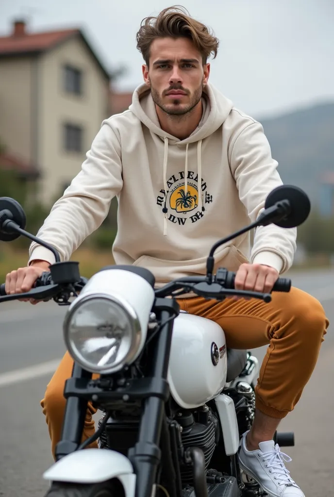 L'image montre un jeune bel homme, à la peau blanche, un physique athlétique, avec des cheveux attachés avec soin, qui porte un sweat à capuche  amande ayant un dessin animé sur la poitrine, assortie à un pantalon de jogging amande, avec des sneakers blanc...