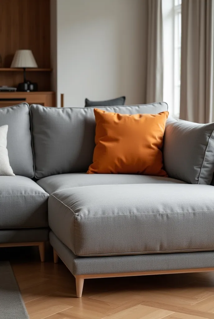 3-seater sofa with gray chaise and two cushions on the left side and an orange cushion on the right side 