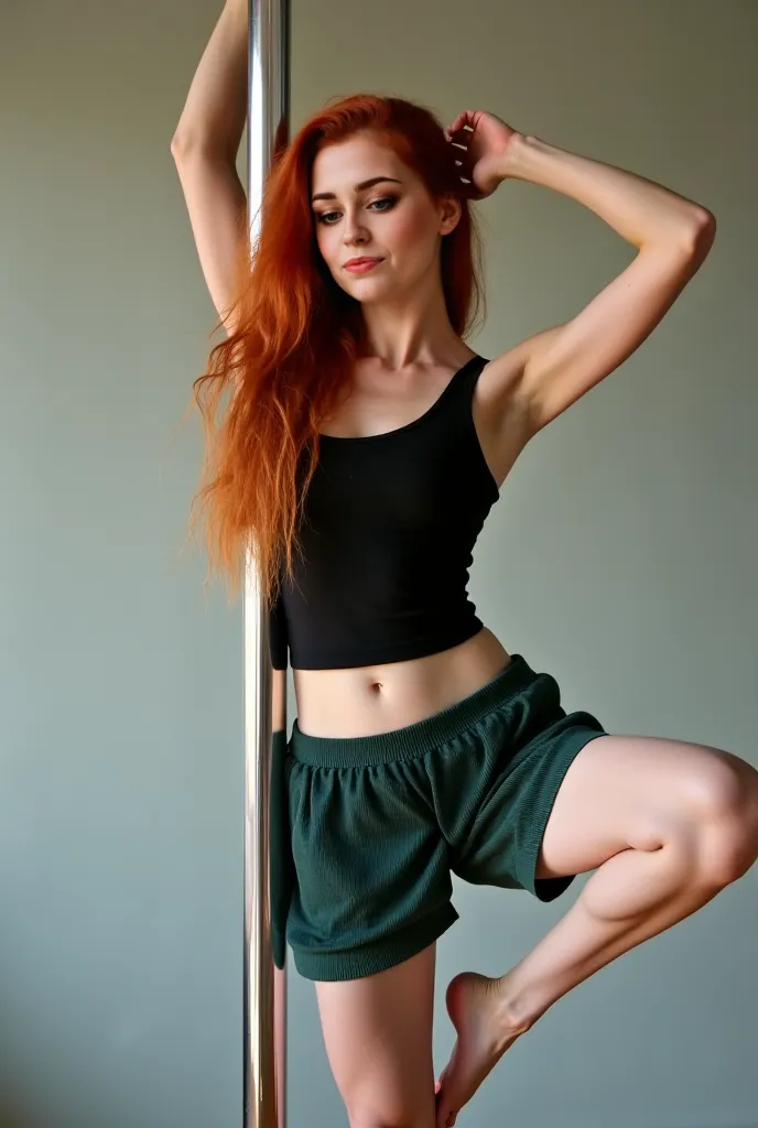 A young woman with red-dyed, long and loose hair, and fair skin performs a basic pole dance move in a softly lit studio. She wears a tight black tank top and loose, comfy dark green knit shorts. Her body is slightly curved as she holds the pole with both h...