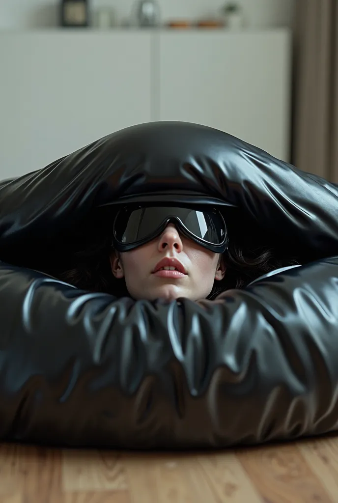 Lindsey Strutt sealed under the top of a black latex vacuum sofa that is lying horizontally in a modern family room, her face is covered in latex