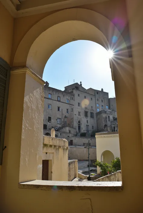 Photo from indoor. extreme low angle view of a window in a house in Sassi di Matera. The shot frames a house outside the window. Framing of the house outside.Photographic shot, lens flare and backlit effect. Clear sky
