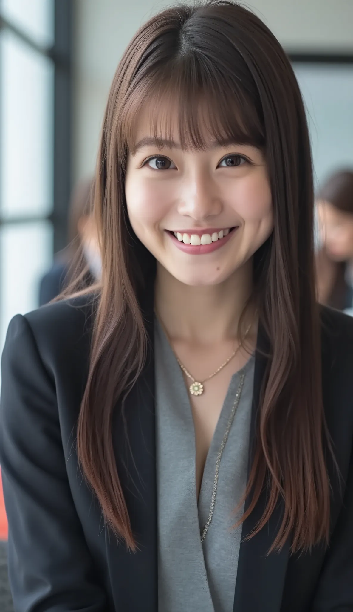 Neat Young Woman、 pale brown hair、Hairstyle Semi Long、and look at the camera、office lady suit、jacket、shirt、ear piercing、necklace、smile showing teeth、people talking in the background is inside the room、