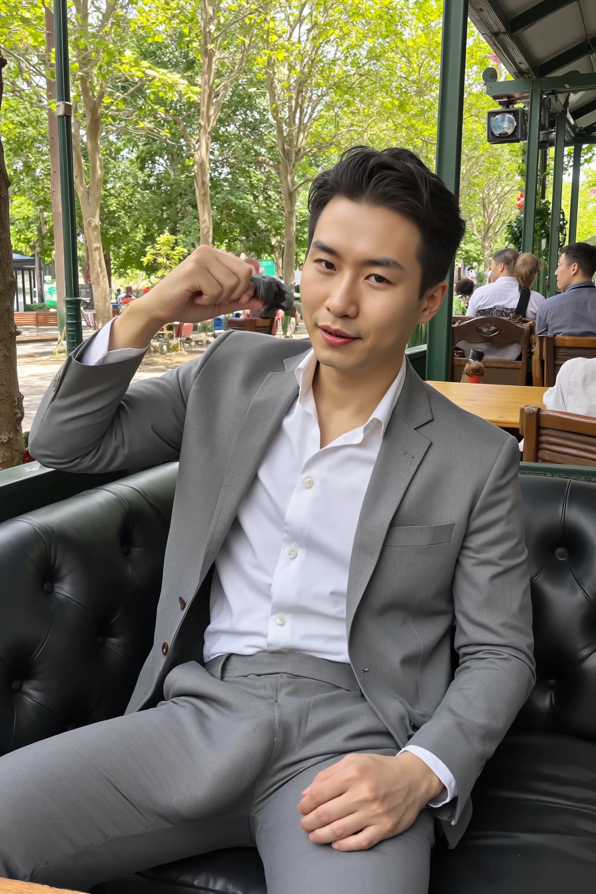 A highly photorealistic image of a stunningly handsome Asian man sitting confidently on a luxurious leather couch in a park. He is wearing a perfectly tailored grey formal suit and a crisp white dress shirt, neat and fully buttoned. His pants are unzipped,...