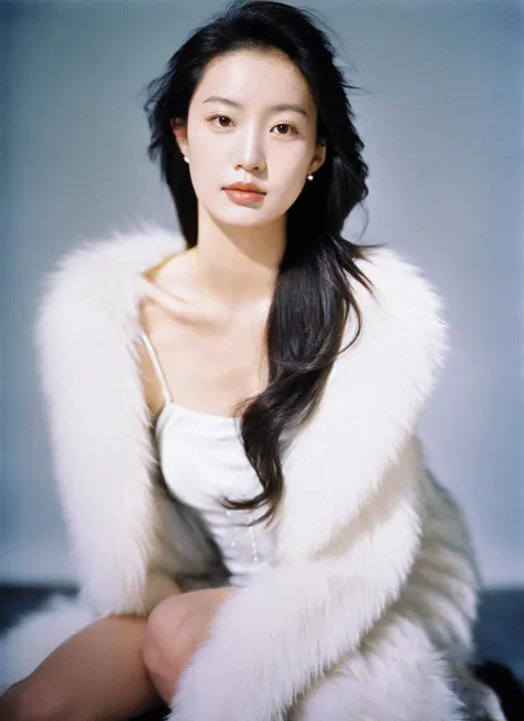 film photography,woman,asian,portrait,studio lighting,long hair,beige top,faux fur coat,kneeled pose,looking at camera,subtle ma...