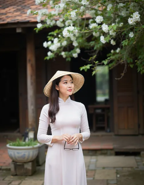 RC Hoang, Vietnamese, aodai v09, a young woman wearing a traditional Vietnamese dress and a straw hat. She is standing in front of a wooden building with a tree with white flowers in the background. The woman is holding a pair of glasses in her hands and a...