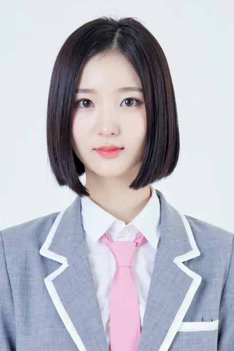 This is a studio photograph featuring an woman against a plain white background. She has a light complexion. She is dressed in a school uniform consisting of a light grey blazer with white trim, a white dress shirt, and a pink tie.<lora:flux_realism_lora:1...