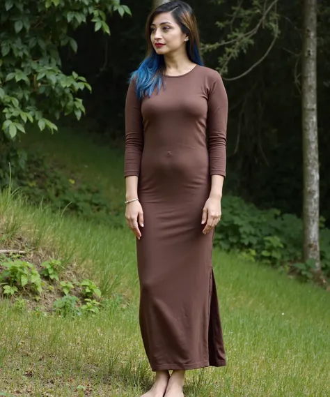 This photograph captures a young woman standing outdoors on a grassy hillside, surrounded by tall trees and lush greenery. She has a light olive complexion and long, wavy brown hair that transitions to vibrant blue at the tips. Her hair cascades over her s...