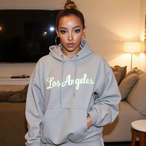 <lora:Tinashe_Flux:1> Tinashe wearing a light gray, oversized hoodie with the words âLos Angelesâ printed across the chest.  Her hair is pulled into a loose bun, and she wears minimal makeup, giving her a fresh-faced look. The setting is a laid-back li...