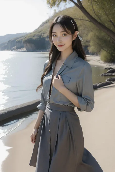 a woman in a gray dress standing on a beach next to the water