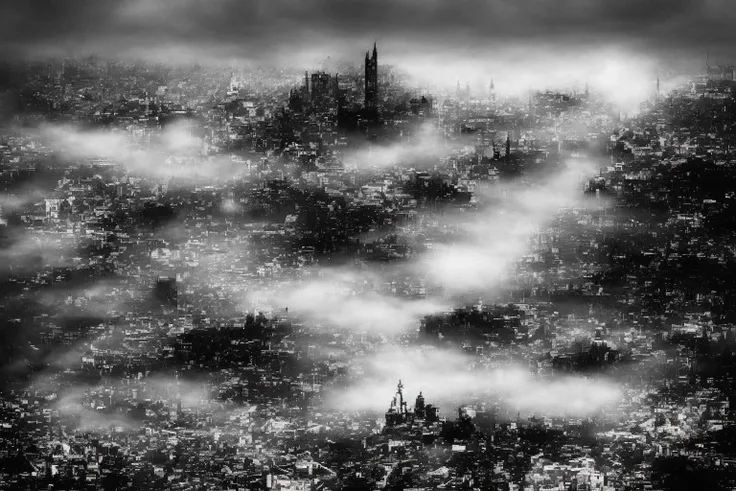 a black and white photo of a city with a lot of fog