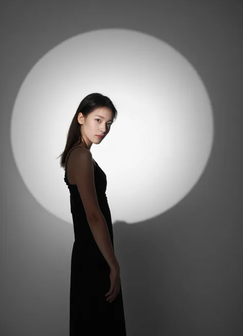 a woman in a black dress standing in front of a white light