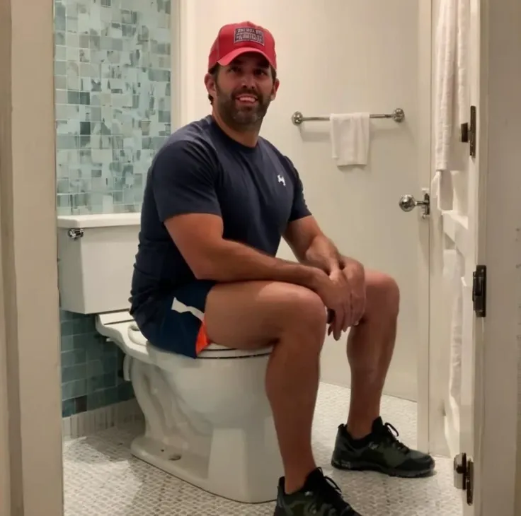 arafed man sitting on a toilet in a bathroom with a blue tiled wall