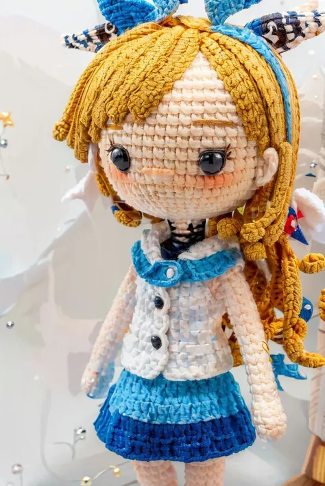 there is a crocheted doll with a blue dress and a white shirt