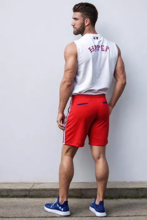 photo by Rick Day, posing in front of a white wall, wearing a sleeveless Phillies hoodie, shorts and Under Armour sneakers,  <lora:BryceHaper:0.8> BryceHarper, from behind, back view, looking back at camera