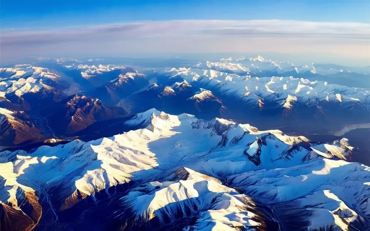 a view of a mountain range with snow covered mountains in the distance