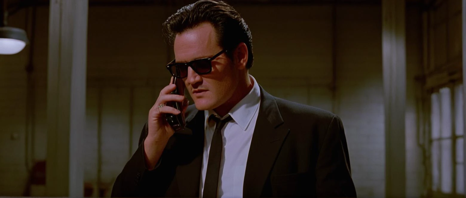 cinematic film still of  <lora:Reservoir Dogs style:1>
Michael Madsen, Cinematic 1992 image focus of Cinematic 1992 image focus of a man in a suit and tie holding a cell phone,solo,short hair,shirt,black hair,long sleeves,1boy,holding,jacket,white shirt,ma...