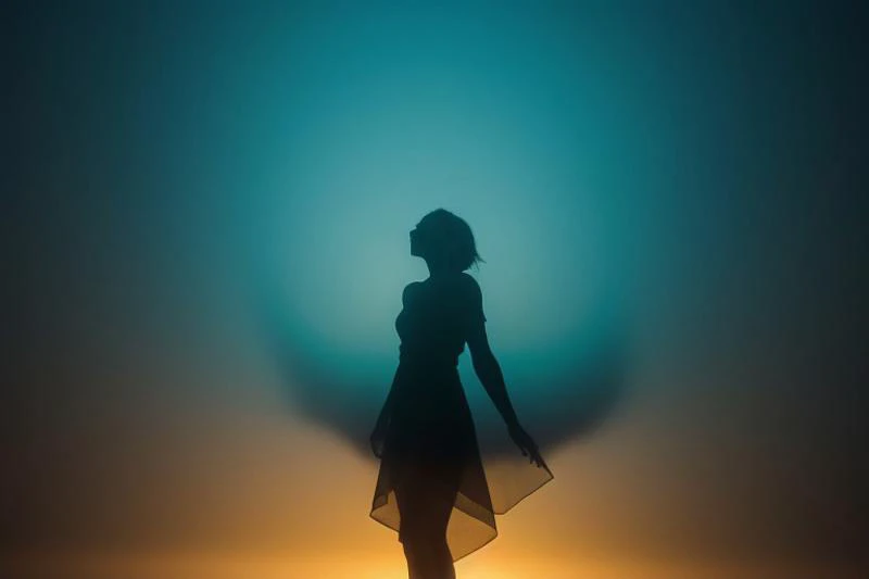 Hyperrealistic photograph of a silhouetted female figure, spectrum. Vertical bands of light transition smoothly from deep teal, through vivid blues, warm yellows, to intense blacks. Figure stands centrally, arms slightly outstretched, draped in flowing, go...