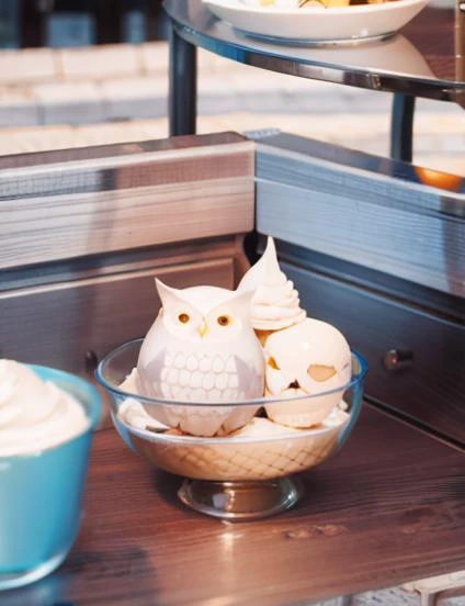 there are two bowls of food on a table with a owl figurine