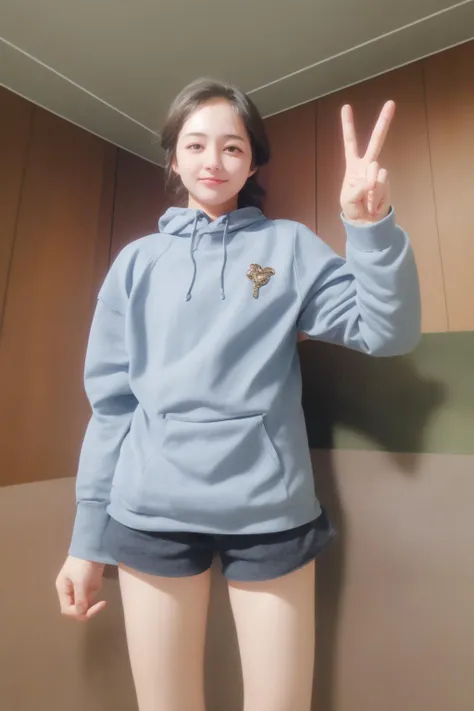 a woman in a blue hoodie and shorts posing for a picture