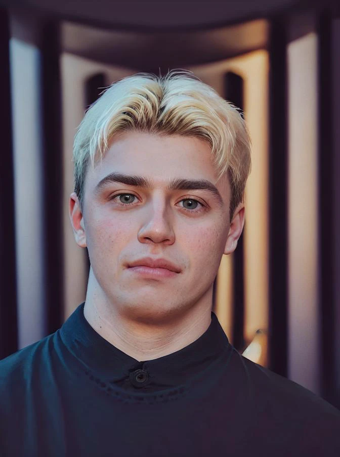 a close up of a man with blonde hair and a black shirt