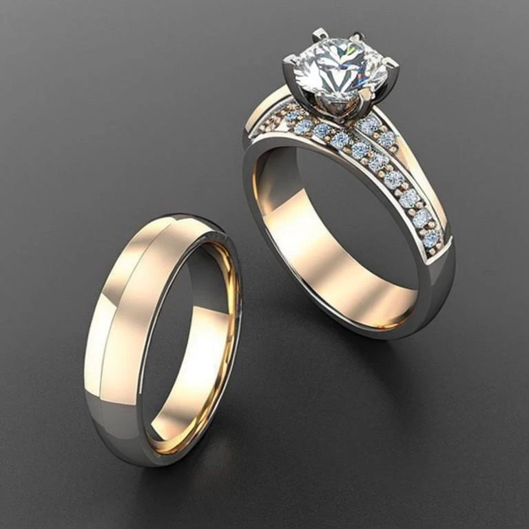 two wedding rings with diamonds on a black surface