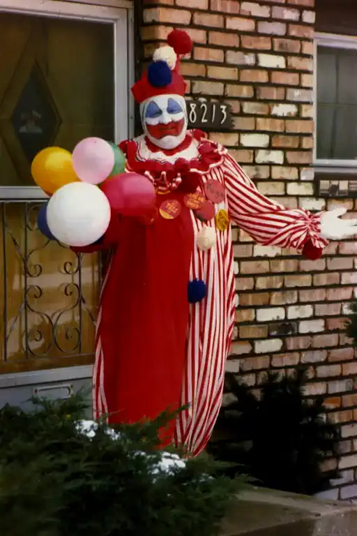 The clown jumps happily, juggling the balloons while spinning in circles in front of the door.