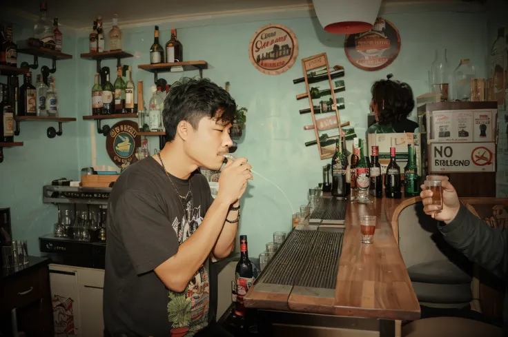 there is a gentleman that is drinking a drink in a bar, another friend shooting his photo