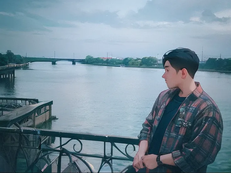 there is a man standing on a bridge looking out over the water, river in front of him, river in the background, shot with a canon 35mm lens, shot with sigma f / 4. 2, shot with sigma f/ 4.2, shot on sony a 7, shot in 35mm, low quality photo, shot on canon ...