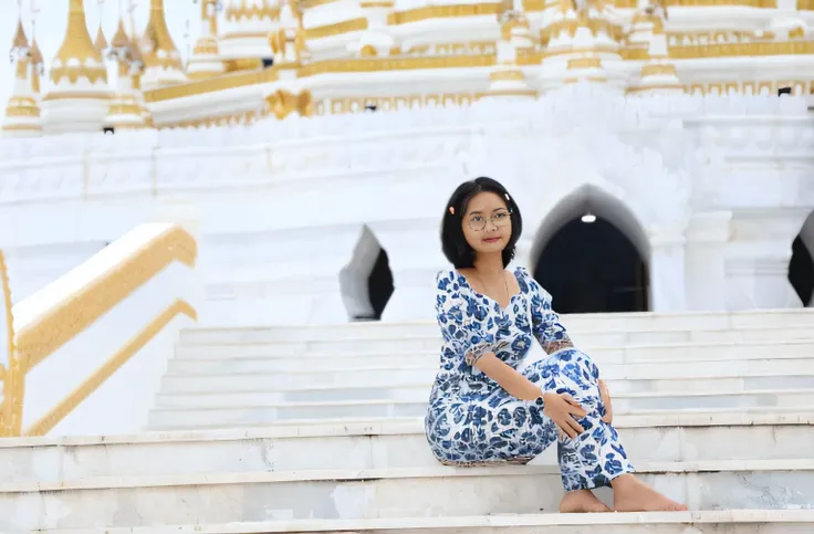 arafed woman sitting on steps in front of a white and gold building, sitting on temple stairs, in front of a temple, temples behind her, in a temple, in front of the temple, standing in a buddhist temple, medium shot portrait, wearing an ornate outfit, tem...