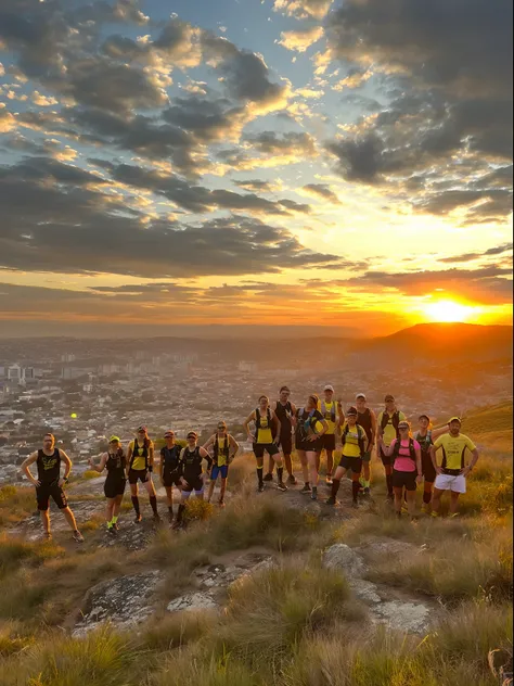 Arafed group of people standing on a hill with a city in the background, As the sun sets on the horizon, aventura, distant view, hora de ouro 8k, hora dourada 8 k, foto ainda, Foto tirada de longe, Sunset!, Inspirador, 2506921471, Motivacional, Best seller...