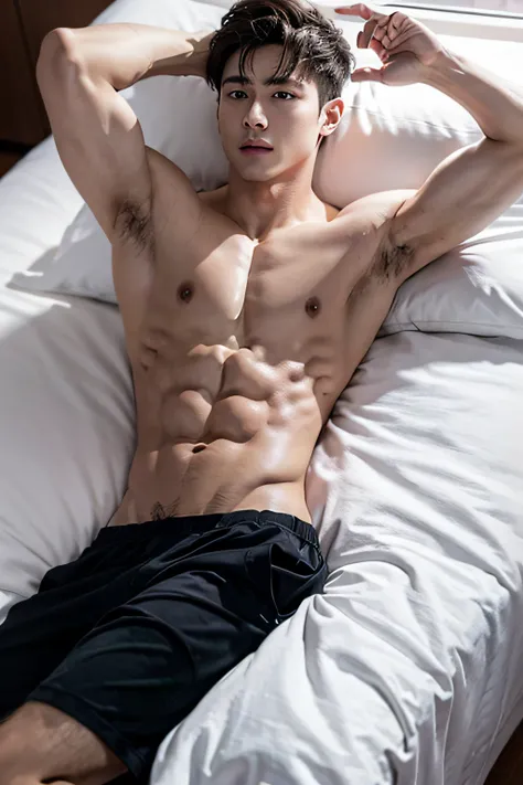 The boy with abs is lying on the bed