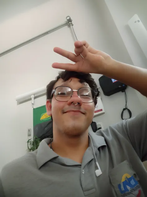 Theres a man in glasses and a gray shirt making peace sign, imagem de qualidade muito baixa, foto de baixa qualidade, foto muito precisa, selfie shot straight on angle, foto de perfil 1024px, em torno de 1 9 anos, foto selfie, fotografia de baixa qualidade...